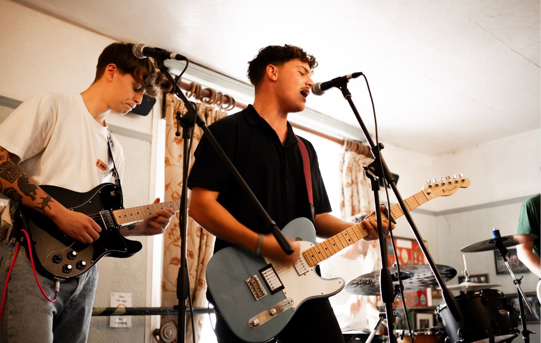 Two guitarists singing into microphones at an intimate pub-room gig